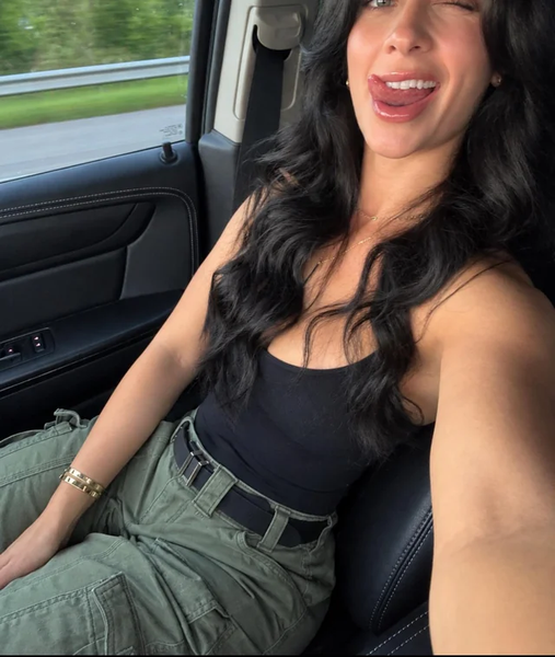 MILF taking a car selfie in a black tank top and cargo pants, tongue out